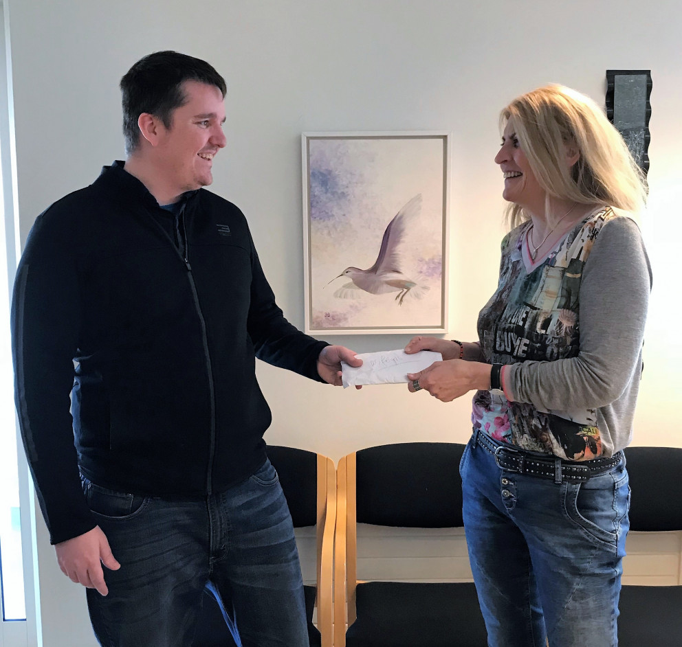 Eiríkur Haraldsson afhendir Ingdísi Líndal umslagið með peningunum sem söfnuðust.